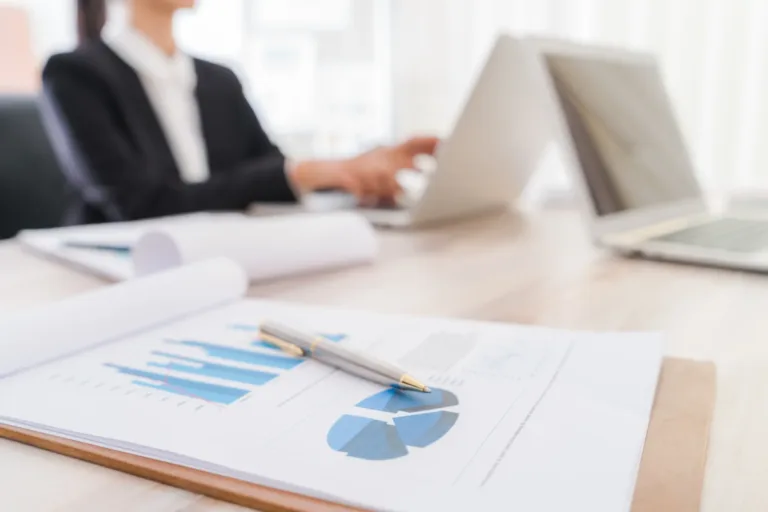 la gente de negocios usando la computadora portatil y cartas financieras en la reunion o