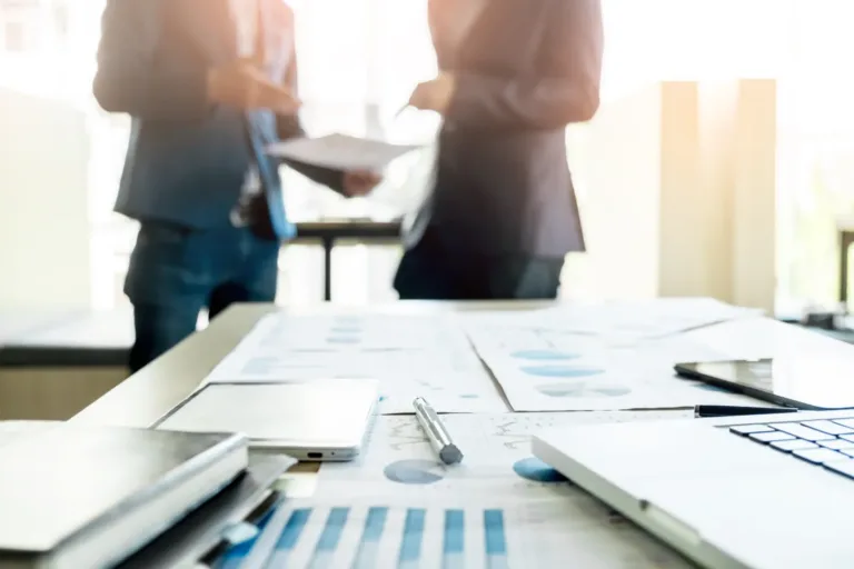 primer plano de escritorio de oficina con equipo de negocios discussting proyecto de trabajo detras